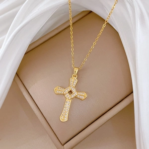 Rotating gold cross necklace with crystals on silk fabric and jewelry box display