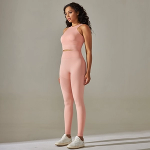 Détail d'un ensemble de yoga rose pêche sans couture avec legging et haut dos nu