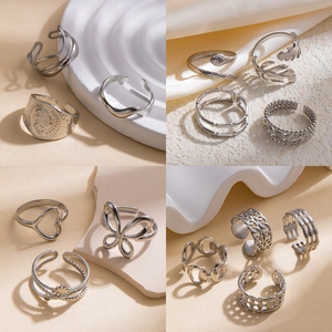 Collection of silver stainless steel rings with snake, heart and leaf designs in a grid