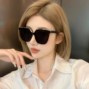 Close-up of oversized square sunglasses worn by a model to showcase facial fit and style