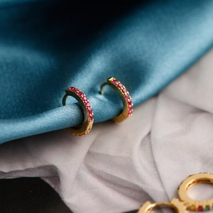 Close-up of gold S925 sterling silver hoop earrings with micro-set red cubic zirconia