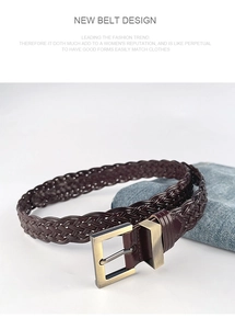 Detail shot of a dark brown braided belt with a vintage brass buckle on denim fabric