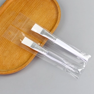 Set of two white face mask brushes with clear handles and soft bristles in individual bags