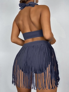 Détail du haut de bikini dos nu bleu marine et de la jupe à longues franges assortie