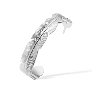 Macro detail of silver feather-shaped open cuff bracelet showing intricate metal textures