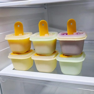Set of 6 DIY popsicle molds with yellow lids shown inside a refrigerator freezer