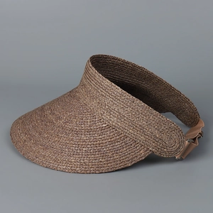 Detail of adjustable elastic band and metal buckle on woven raffia sun visor hat