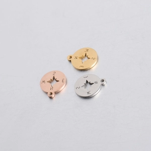 Detailed view of compass star pendants in gold, rose gold and silver stainless steel