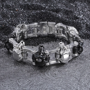 Detail eines silber-schwarzen Totenkopf-Gliederarmbands für Herren auf schwarzem Sand
