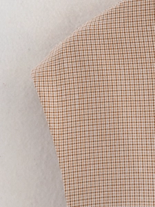 Dettaglio del tessuto classico pied de poule marrone e beige con trama del materiale fine