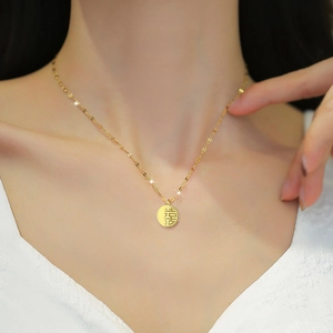 Collana in acciaio al titanio dorato con pendente Fu traforato, indossata da modella