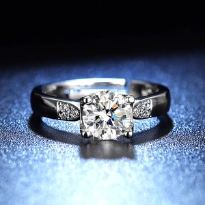 Macro shot of 1 carat round moissanite ring with side stones on dark starlight background