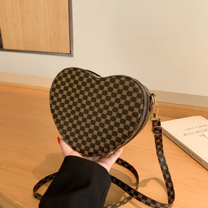 Dettaglio borsa a tracolla a forma di cuore con motivo a trifoglio e fibbia dorata