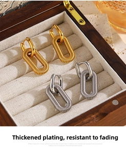 Close-up of gold and silver U-shaped oval earrings with thick electroplating texture