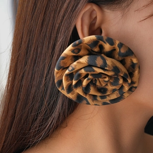 Close-up of oversized leopard print fabric rose earrings on a model showing realistic details