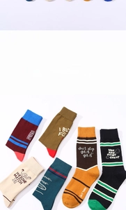 Vue à plat de chaussettes en coton colorées avec rayures et slogans anglais sur blanc