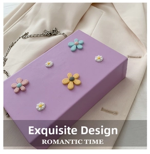 Detail of purple crossbody bag with textured leather and 3D floral chain ornaments