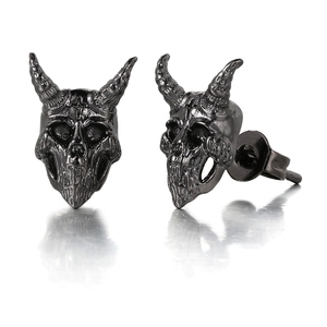 Close-up of black metal skull earrings in gothic punk style with reflective mirror effect