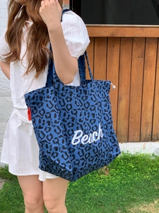 Outdoor-Aufnahme einer blauen Canvas-Einkaufstasche mit Leopardenmuster und Beach-Aufdruck