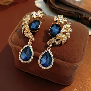 Boucles d'oreilles vintage dorées avec pierres bleu foncé et motifs floraux