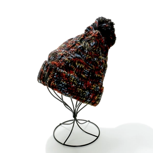 Close-up of thick multi-color knit beanie texture with a top pompom on display stand