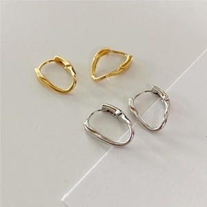 Detailed view of minimalist curved irregular earrings in polished gold and silver finishes