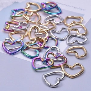 Macro detail of heart-shaped stainless steel DIY jewelry links in gold, silver and rainbow colors