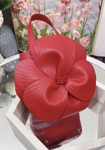Detail view of red 3D floral tote bag with layered leather petals and protective studs