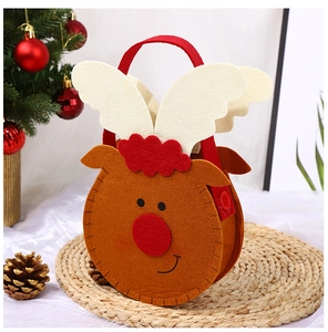 Close-up of brown felt reindeer Christmas gift bag with festive holiday decorations
