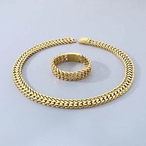 Polished gold mesh chain heart necklace and bracelet set on a clean background
