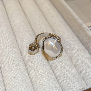 Detail of silver irregular ring with large baroque pearl on beige velvet background