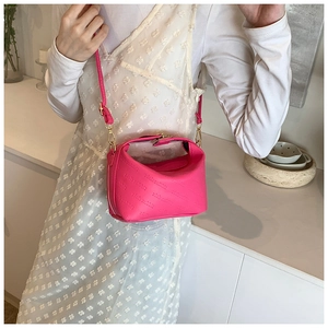 Détail du sac polochon rose vif en cuir avec motif rich rabbit gaufré et finitions dorées