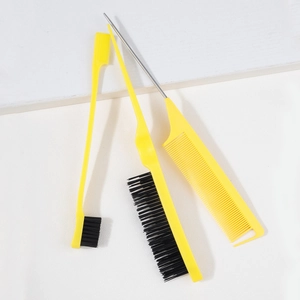 Macro shot of 3-piece yellow hair styling kit including tail comb and edge control brush