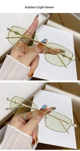 Detail of golden rectangular sunglasses with wavy geometric temples and light green lenses