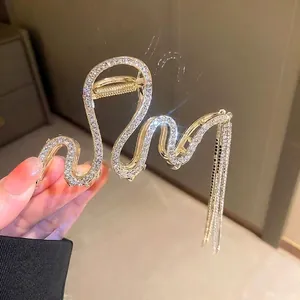 Elegant gold snake-shaped hair claw clip with rhinestones and shimmering long tassels