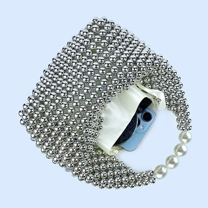 Detailed top view of silver beaded bag with pearls showing interior satin lining capacity