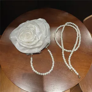 Detailed view of 3D camellia evening bag with elegant pearl shoulder strap
