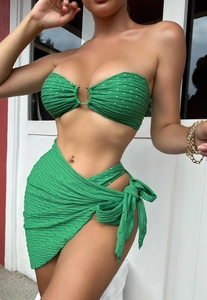 Detail of green polka dot bikini top with central gold ring and pleated texture fabric