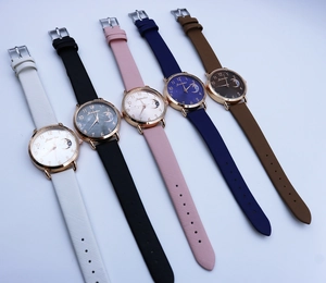 Detail view of five quartz watches with moon phase dials and colored textured straps