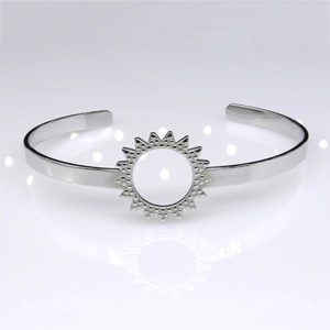Detailed macro view of silver stainless steel cuff bracelet with sunburst hollow design