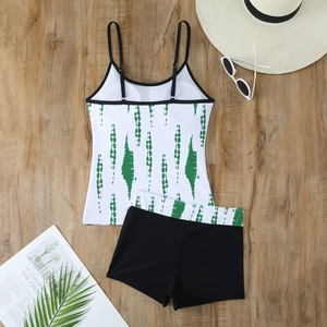 Detail of adjustable black straps and white tankini top with green brush pattern