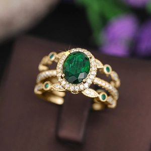 Macro shot of gold-plated oval green gemstone ring with pavé diamonds and filigree
