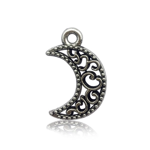 Detail of vintage silver crescent moon pendant with intricate hollow vine patterns