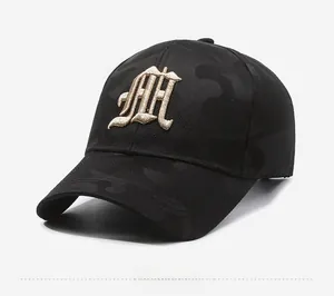 Detail of golden gothic AH embroidery on camo textured black baseball cap side view