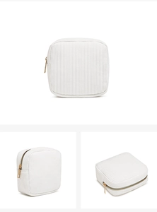 Detail view of white corduroy mini cosmetic bag with premium gold zipper and square shape