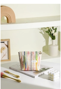 Détail du sac en tissu rayé multicolore avec tirette de fermeture florale