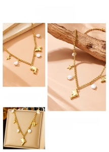 Detailed view of a gold chain necklace with dolphin, starfish, and pearl charms