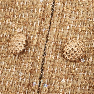 Short tweed two-piece set featuring golden sequins and woven buttons with metallic thread