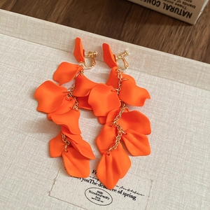 Detail of orange petal tassel clip-on earrings with elegant gold chains for non-pierced ears