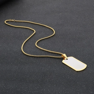 Détail d'un collier pendentif rectangulaire doré avec incrustation blanche sur chaîne